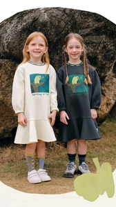 Detail of girl's cotton dress showing owl print and ruffled hem in outdoor setting