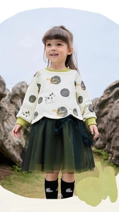 Detail von Mädchen-Sweatshirt mit Punkten und grünem Lagenrock aus Netzstoff mit Print