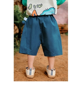 Rear view of children's loose navy blue casual shorts in an outdoor nature setting