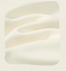 Close-up of soft warm white knitted fabric texture showing high-quality cotton weave