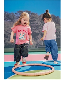Kinderen die roze T-shirts en ademende joggingbroeken dragen tijdens het buiten spelen