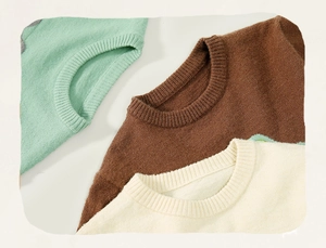 Detail van de geribbelde ronde hals op kindertruien in groen, bruin en beige kleuren