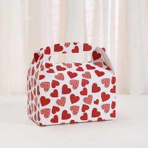 White cardboard gift box with red heart patterns and integrated handles for desserts