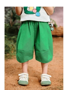 Detail shot of bright green loose fit kids shorts made of breathable cotton fabric