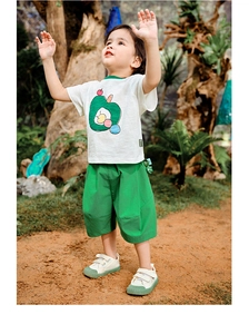 Detail of boys' white t-shirt with green apple graphic and casual green shorts set