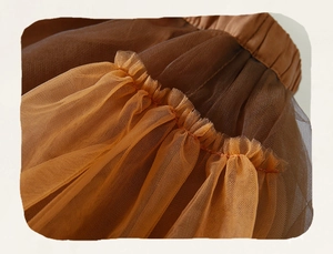 Dettaglio dell'elastico in vita e degli strati di tulle bicolore marrone e arancione