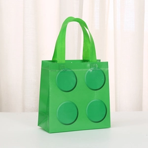 Detail view of grass green non-woven gift bag with creative 3D building block pattern