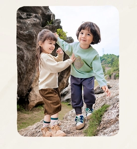Buitenopname van kinderen in gebreide truien met corduroy shorts en modieuze laarzen