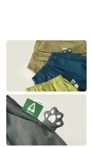 Detail of children's cotton shorts with elastic waistband and cute 3D paw ornament