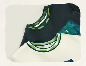 Detail of girls' ribbed crew neck with green polka dot pattern and soft cotton texture