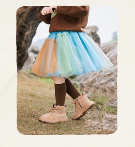 Dettaglio di una gonna tutu a strati in tulle colorato con maglia arancione e verde chiaro