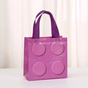 Close-up of purple non-woven gift bag with embossed brick pattern and reinforced handles