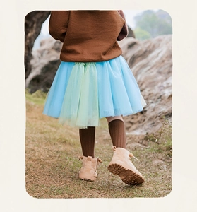 Dettaglio gonna tutu colorata da bambina con strati di tulle blu e verde all'aperto