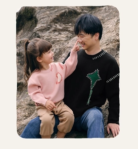 Detail of parent-child knit sweater with textured geometric hand-stitched patterns