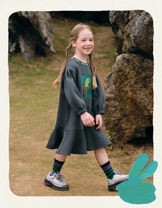 Close-up of girls' grey sweatshirt dress with green floral print and ruffle hem
