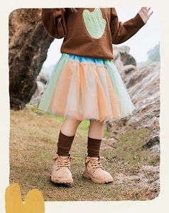 Dettaglio maglione marrone in maglia da bambina con gonna in tulle multicolore