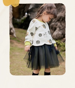 Details des Polka-Dot-Sweatshirts mit gestuftem Tüllrock und floralen Akzenten