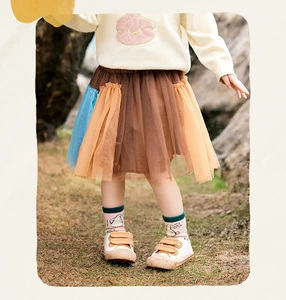 Dettaglio della gonna a balze in tulle multicolore per bambina con strati arancioni
