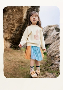 Dettaglio di bambina con maglione in maglia a coniglio e gonna in tulle multicolore