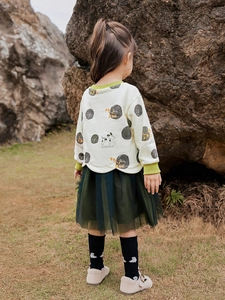 Mädchen-Herbstoutfit mit cremefarbenem Sweatshirt und dunkelgrünem Lagen-Tüllrock