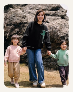 Detail of knitted parent-child sweaters with patch embroidery and contrast stitching