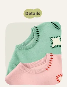 Detail of round neck knitted sweater featuring contrast stitching in mint and pink colors