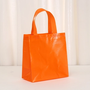 Close-up of orange non-woven tote bag showing diamond woven texture and sturdy handle