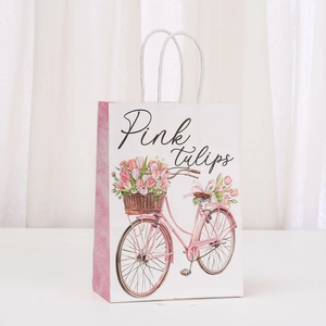 Detail of white kraft paper gift bag featuring pink tulip bicycle and rope handles