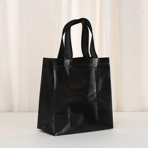 Close-up of black glossy non-woven tote bag with grid texture and waterproof film coating