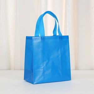 Detail of blue non-woven bag showing durable cross-embossed texture and reinforced handle