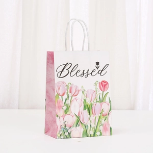White floral kraft gift bag with pink tulips, woven handles and Blessed text decoration