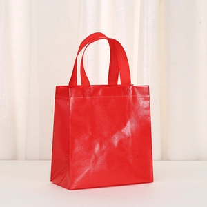 Detail of red non-woven gift bag with waterproof coating and reinforced handle stitches
