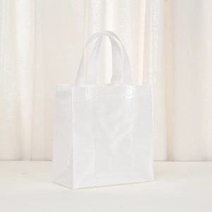 Detail of white non-woven gift bag showing square textured pattern and glossy finish