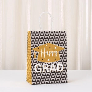 Close-up of Graduation gift bag with golden mortarboard pattern and white rope handle