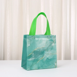 Laminated non-woven marble print gift bag with green handles and gold sand pattern