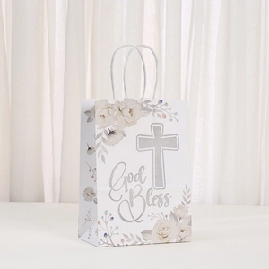 Detail of white kraft paper gift bag with floral prints and silver glitter cross God Bless