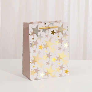 Elegant white Christmas gift bag with gold star patterns and golden rope handles