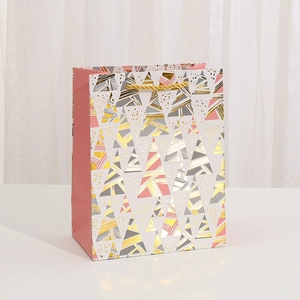 Modern Christmas gift bag with pink and gold foil geometric trees and gold handles