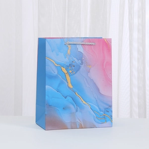 Detail of marble pattern gift bag with fluid art texture and silver rope handles