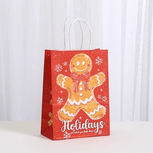 Gros plan du sac cadeau rouge de Noël avec bonhomme de pain d'épices et texte de fêtes