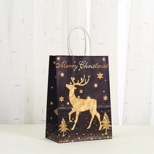 Detail van een zwarte kerstcadeautas met goudkleurige rendierprint en witte handvaten