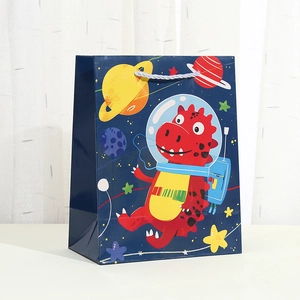 Close-up of astronaut dinosaur gift bag with blue rope handle and space print