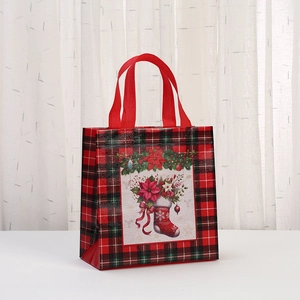 Detail of red and black plaid Christmas gift bag with festive poinsettia and stocking prints