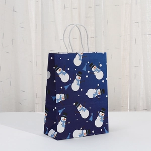 Close-up of blue Christmas paper gift bag with snowman patterns and white rope handles