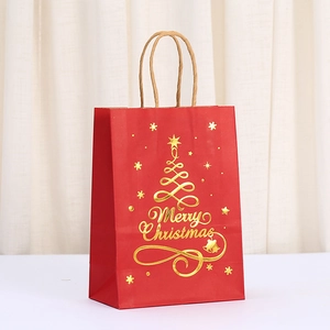 Detail of red Christmas gift bag with golden foil tree and Merry Christmas text