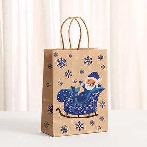 Detail of Christmas kraft paper gift bag with blue Santa sleigh and snowflake prints