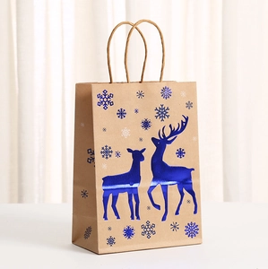 Blue kraft gift bag featuring gold reindeer and snowflake patterns with paper handles