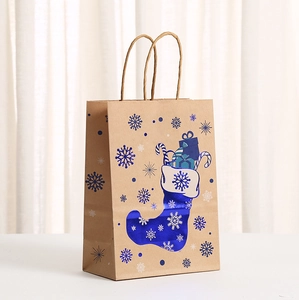 Close-up of blue metallic foil snowflake and stocking patterns on kraft gift bags