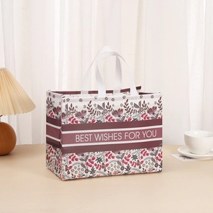 Detail of floral non-woven gift bag with Best Wishes text in a cozy home setting