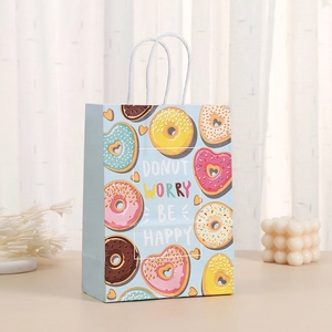 Detail of blue paper donut gift bag with white handles and donut worry be happy text